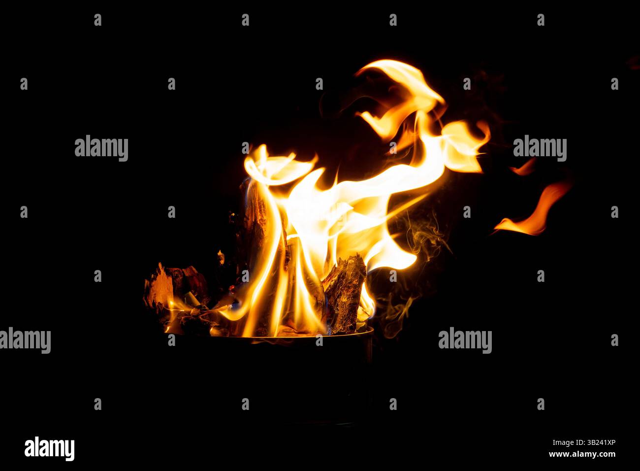 Nahaufnahme von hellen Flammen von einem Feuer im Freien, brennendem Holz und glühendem natürlichem Licht. Stockfoto