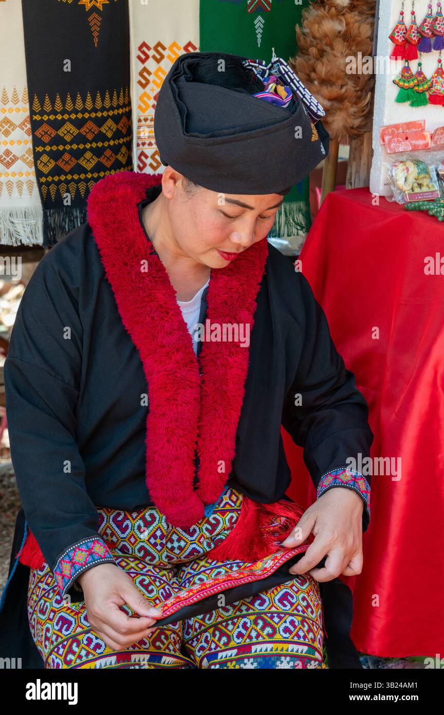 Eine „Akha“-Frau in einem handgefertigten Souvenirladen von Akha, geteilt mit dem langhalsigen Karen-Stamm, der Messingringe trägt, im Dorf Mai Rim ne Stockfoto