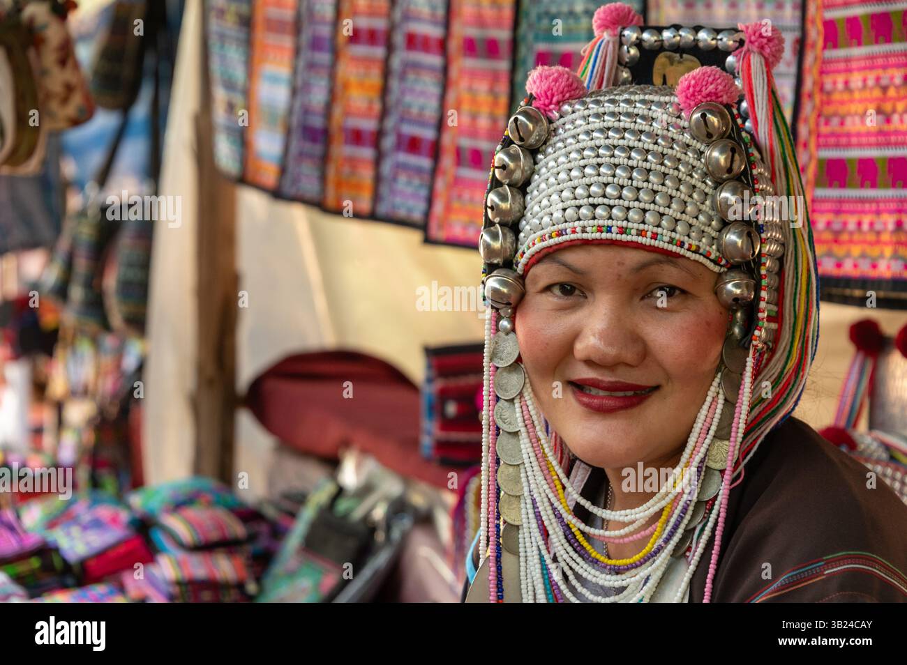Eine „Akha“-Frau in einem handgefertigten Souvenirladen von Akha, geteilt mit dem langhalsigen Karen-Stamm, der Messingringe trägt, im Dorf Mai Rim ne Stockfoto