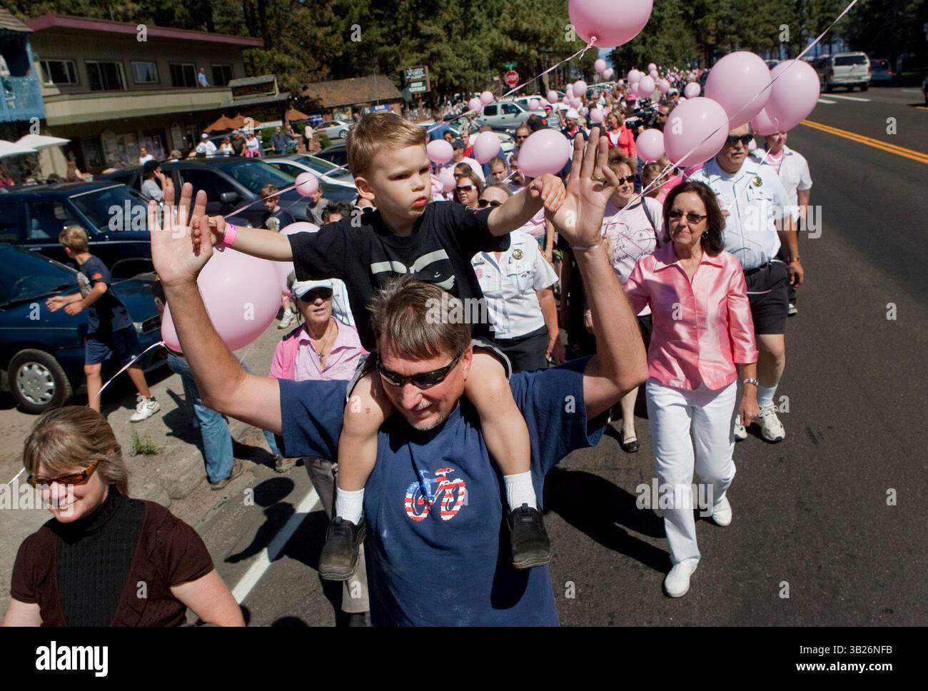 48492 SOUTH LAKE TAHOE, Kalifornien, Jeff Bender und sein Sohn Jonathan, 3, marschieren zu einer South Lake Tahoe Parade zu Ehren der sicheren Rückkehr von Jaycee Lee Dugard, 6. September 2009. In South Lake Tahoe ist sie vor 18 Jahren verschwunden, während sie auf einen Schulbus wartete. Die Parade ist die Umkehrung der Strecke, die am 10. Jahrestag des Verschwindens Dugards zurückgelegt wurde. Die Teilnehmer trugen rosa, weil das Dugards Lieblingsfarbe war. Ihre Klassenkameraden an der Meyers Elementary School starteten zur Zeit ihrer Entführung eine rosa Bandkampagne, um ihre Hoffnung auf ihre sichere Rückkehr zu zeigen... Robert Durell / SPE Stockfoto