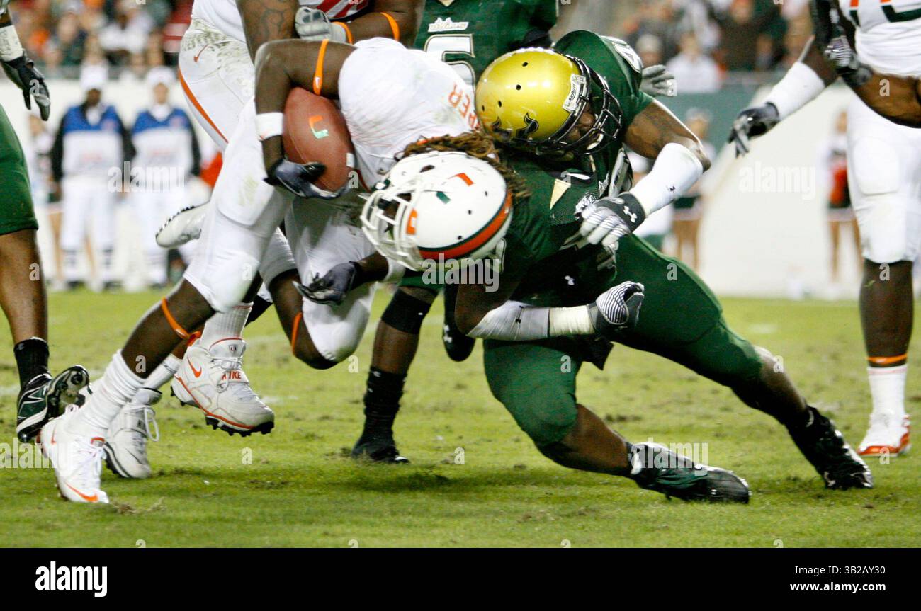 NOVEMBER 2009 - TAMPA, FL, USA - WILLIE J. ALLEN JR. | Times .TP_312214_ALLE_BULLS.(11/28/2009 Tampa) Miamis Running Back Graig Cooper (2) wird im dritten Quartal des Spiels von den Bulls Chris Robinson (49) hart getroffen. Finale 31-10 Miami...Beschreibung Spiel der University of Miami Hurricanes und der University of South Florida Bulls Samstag, 28. November 2009 im Raymond James Stadium, Fla. [WILLIE J. ALLEN JR., Times] (Bild: © St. Petersburg Times/ZUMApress.com) Stockfoto