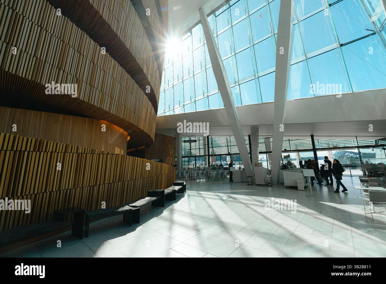 Oslo, Norwegen - 13. April 2024: Menschen, die spazieren gehen und entspannen in der Oper Oslo, Einem modernen architektonischen Gebäude mit schrägem Dach am Ufer. Stockfoto