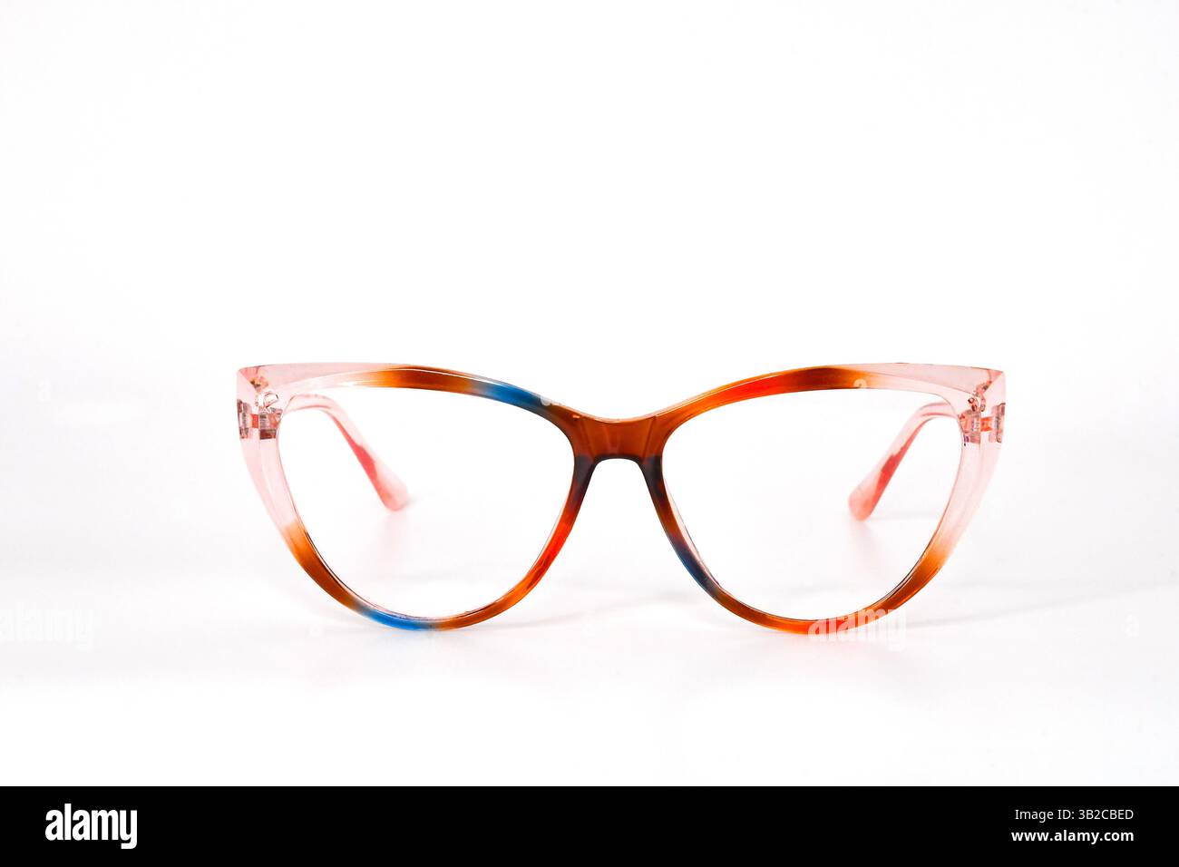 Nahaufnahme einer Damenbrille mit transparentem Rahmen in Form von Katzenaugen in Pink, Blau und Braun, isoliert vor einem schlichten Hintergrund Stockfoto