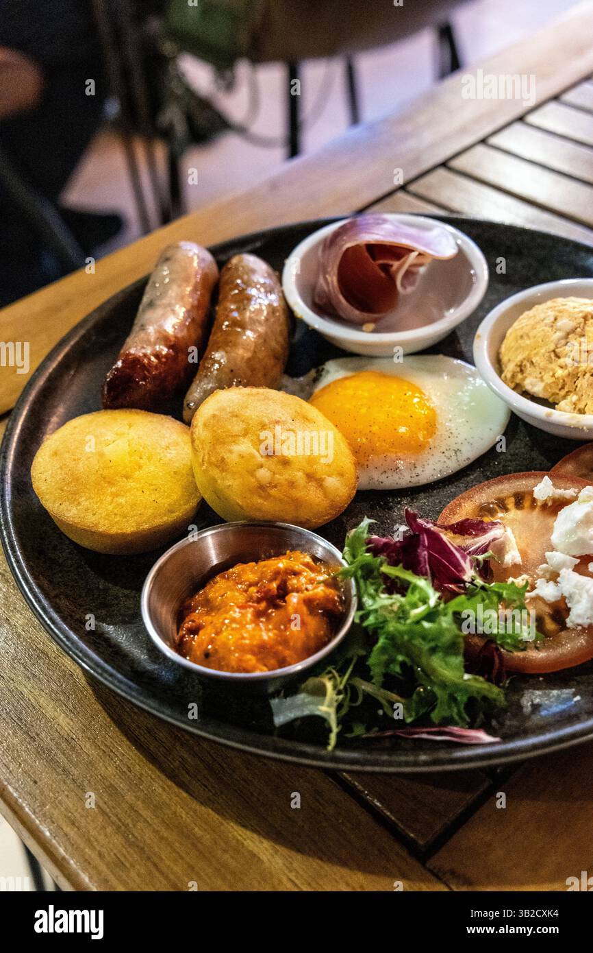 Balkan-Frühstück mit Proja-Maismuffin, Ajvar und Urnebes in der Burnt Umber Brasserie, Hackney Wick, London, England Stockfoto