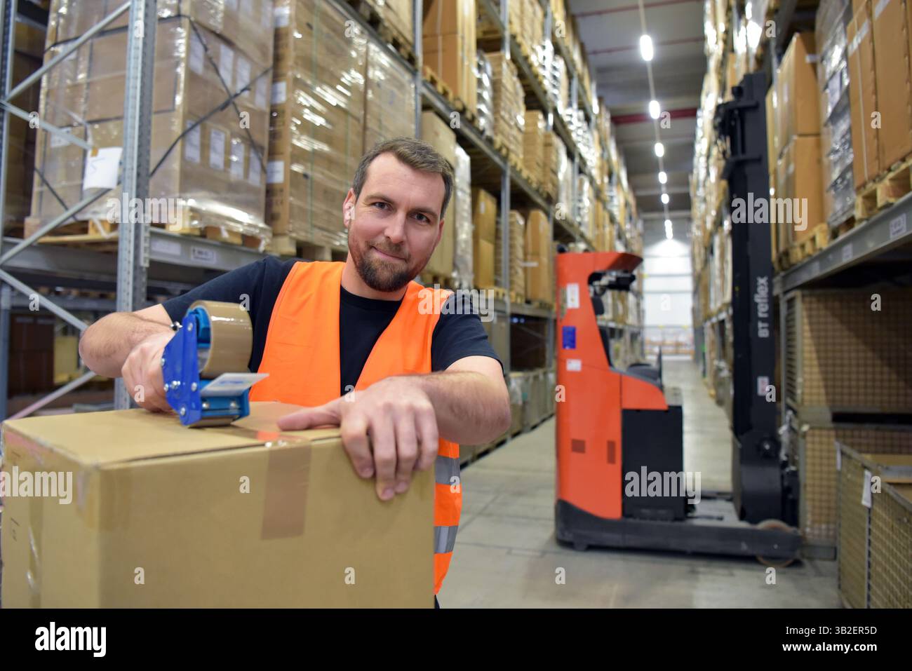 Arbeiter in einem Warenlager im Einzelhandel verpackten ein Paket mit Klebeband Stockfoto