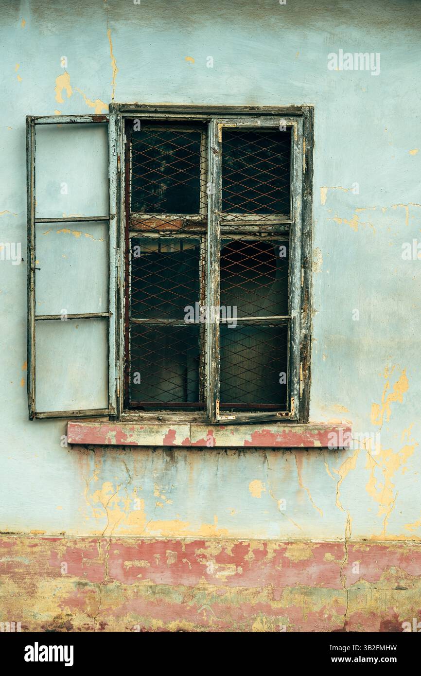 Altes kaputtes Holzfenster eines ruinierten Hauses, vertikales Bild Stockfoto