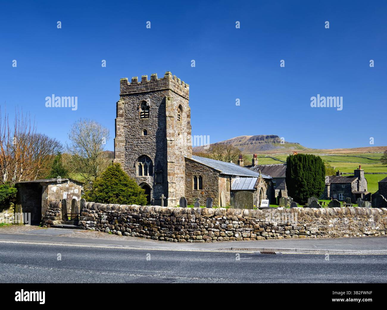 UK, North Yorkshire, Yorkshire Dales, Horton-in-Ribblesdale, St. Oswald's Church mit Pen-y-Ghent in der Ferne. Stockfoto