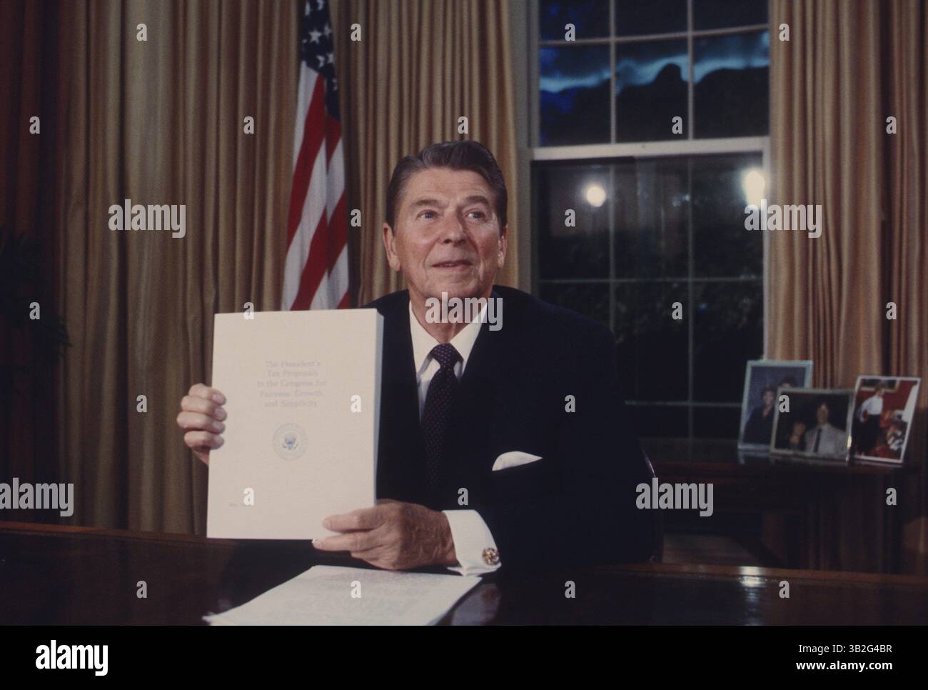 15. Mai 2015 - Washington, District of Columbia, Vereinigte Staaten von Amerika - Washington DC. 5.-28.-1985.Präsident Ronald Reagan .hält eine Kopie des geplanten Steuerreformgesetzes während seiner Fernsehansprache von The Oval Office in die Hand. Credit: Mark Reinstein (Credit Image: © Mark Reinstein via ZUMA Wire) Stockfoto