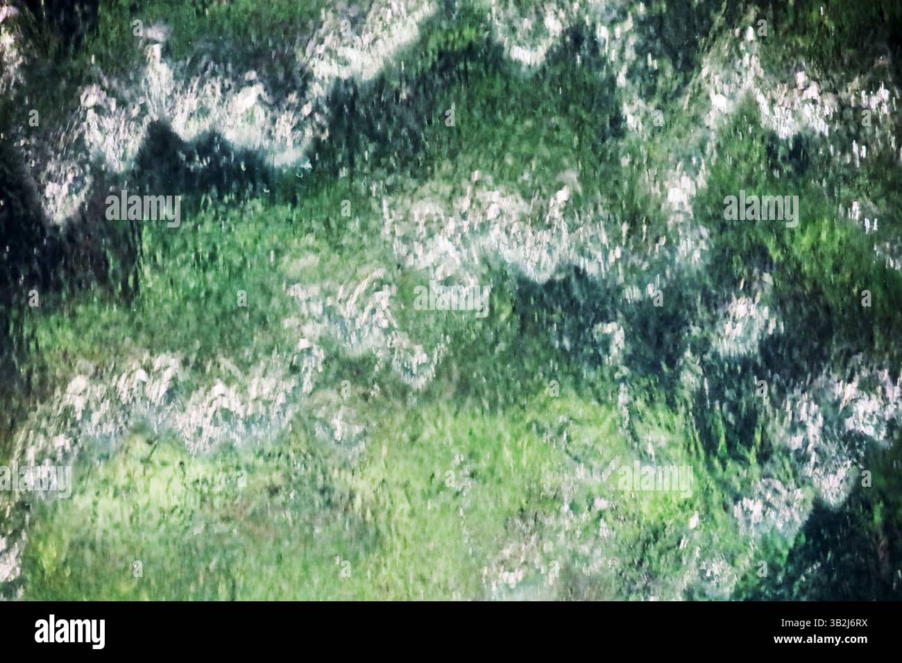 Nahaufnahme eines grün leuchtenden künstlichen Wasserfalls als Hintergrundmaterial Stockfoto