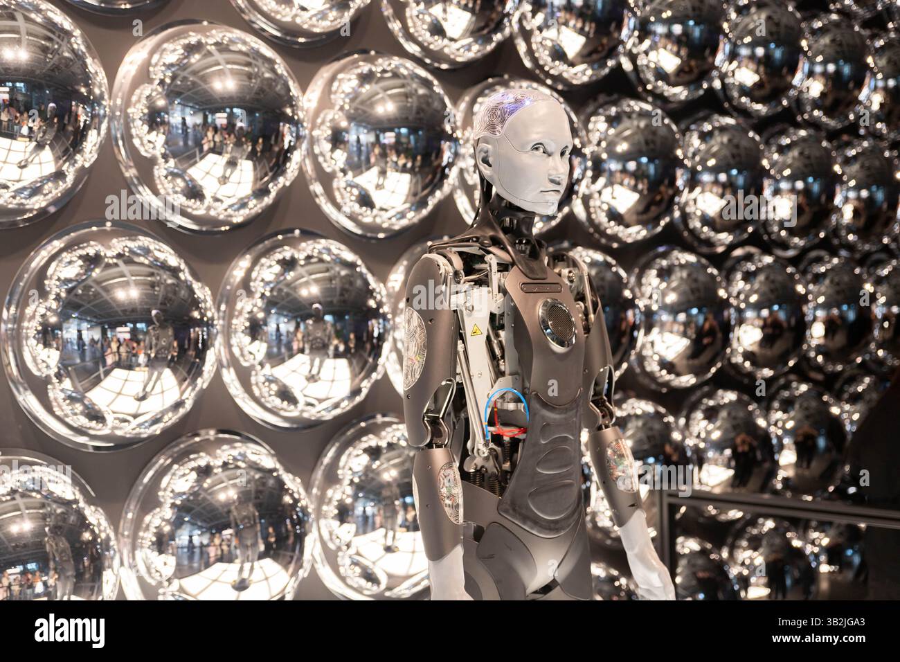 Roboter, der am Computer arbeitet, unter Menschen. Maschinelles Tippen auf der Tastatur im Büro. IT-Team der Zukunft. Futuristischer Mitarbeiter. Humanoide Arbeit im Call Center. Sup Stockfoto