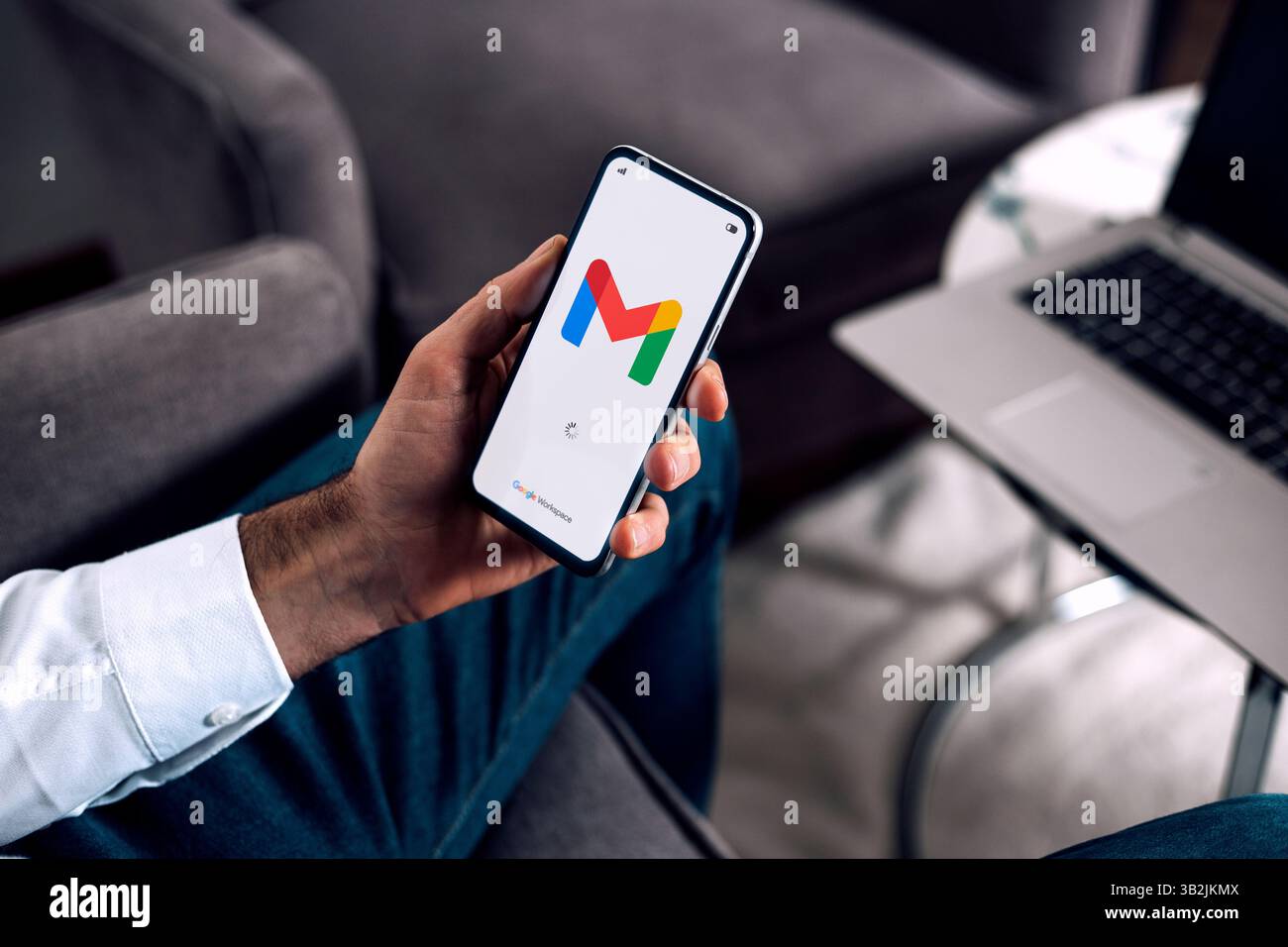 Geschäftsmann im Büro, der ein Mobiltelefon hält und die Gmail-App für E-Mails von Google Workspace öffnet. ROSARIO, ARGENTINIEN - 22. APRIL 2025. Stockfoto