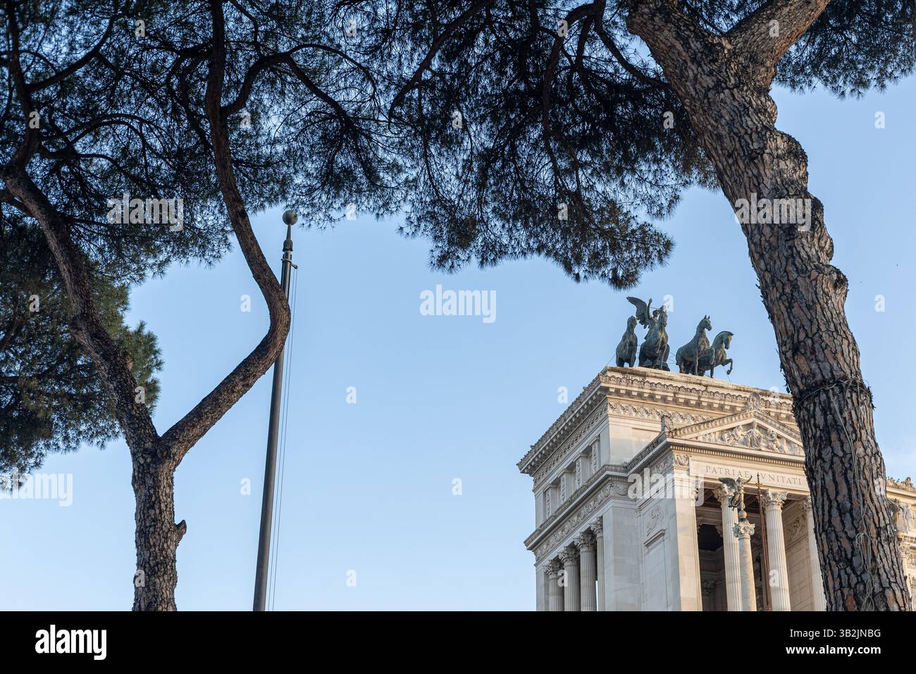 Victor Emmanuel II. Monument eingerahmt von Bäumen unter blauem Himmel. Stockfoto