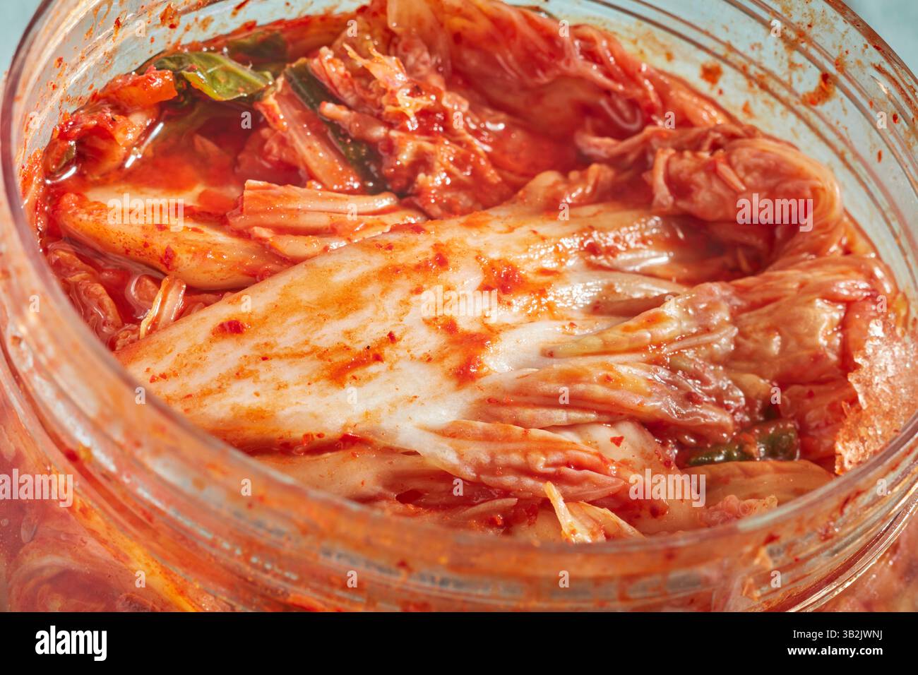 Ein großes Plastikglas Napa Cabbage Kimchi, gefüllt bis oben Stockfoto