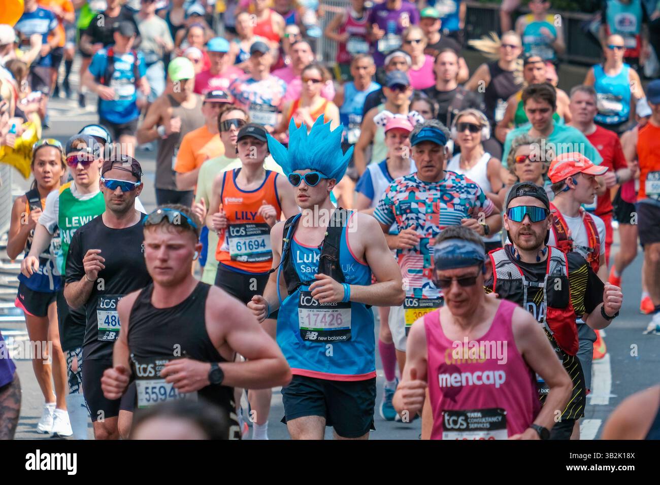 Die Läufer des Londoner Marathons 2025 absolvieren den Kurs, manchmal überlastet und bei warmen Bedingungen, da die Temperatur 22,2 °c erreicht. Stockfoto