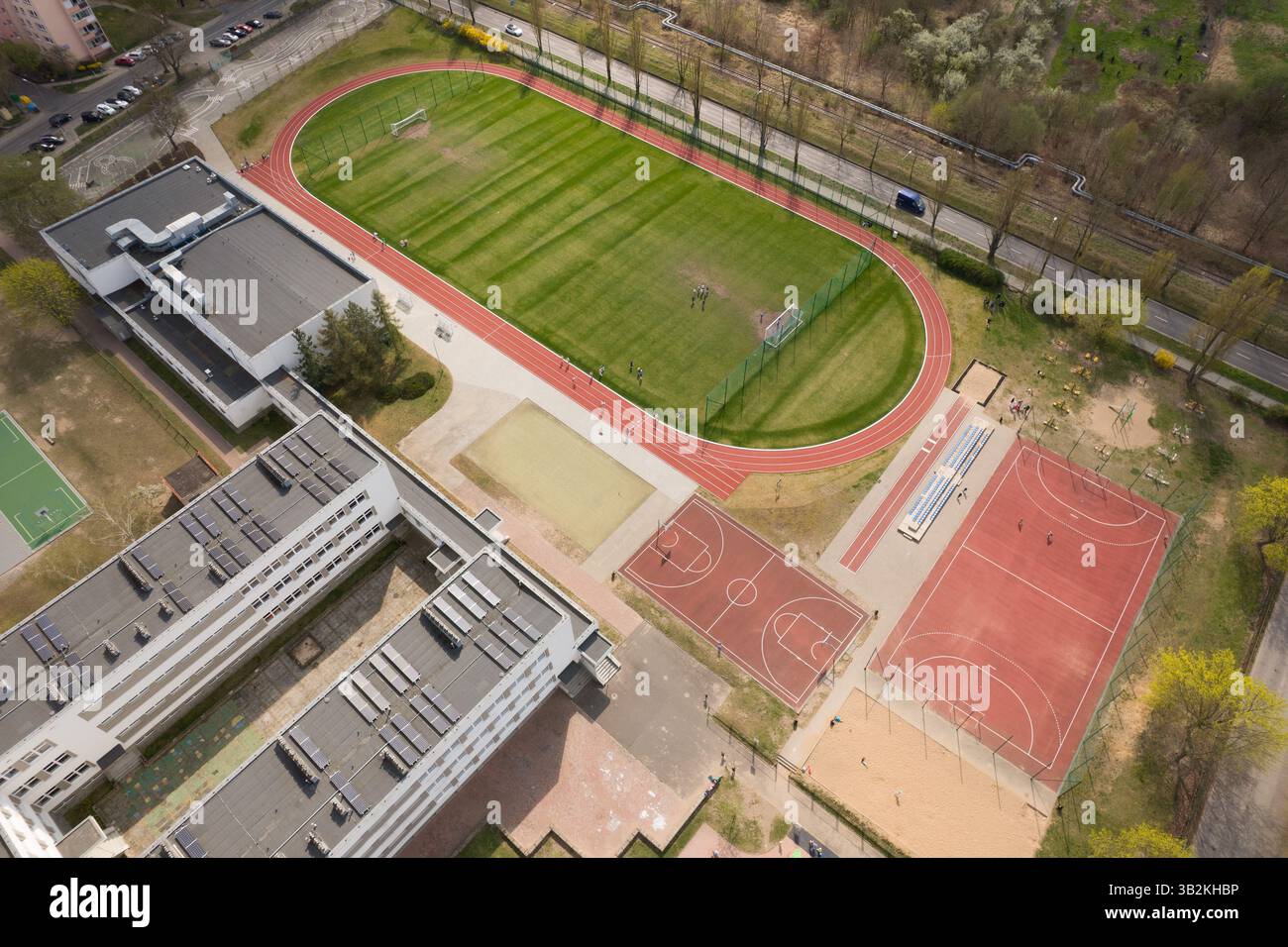 Schulkomplex mit Sportfeldern und Stadtlandschaft - aus der Vogelperspektive. Stockfoto