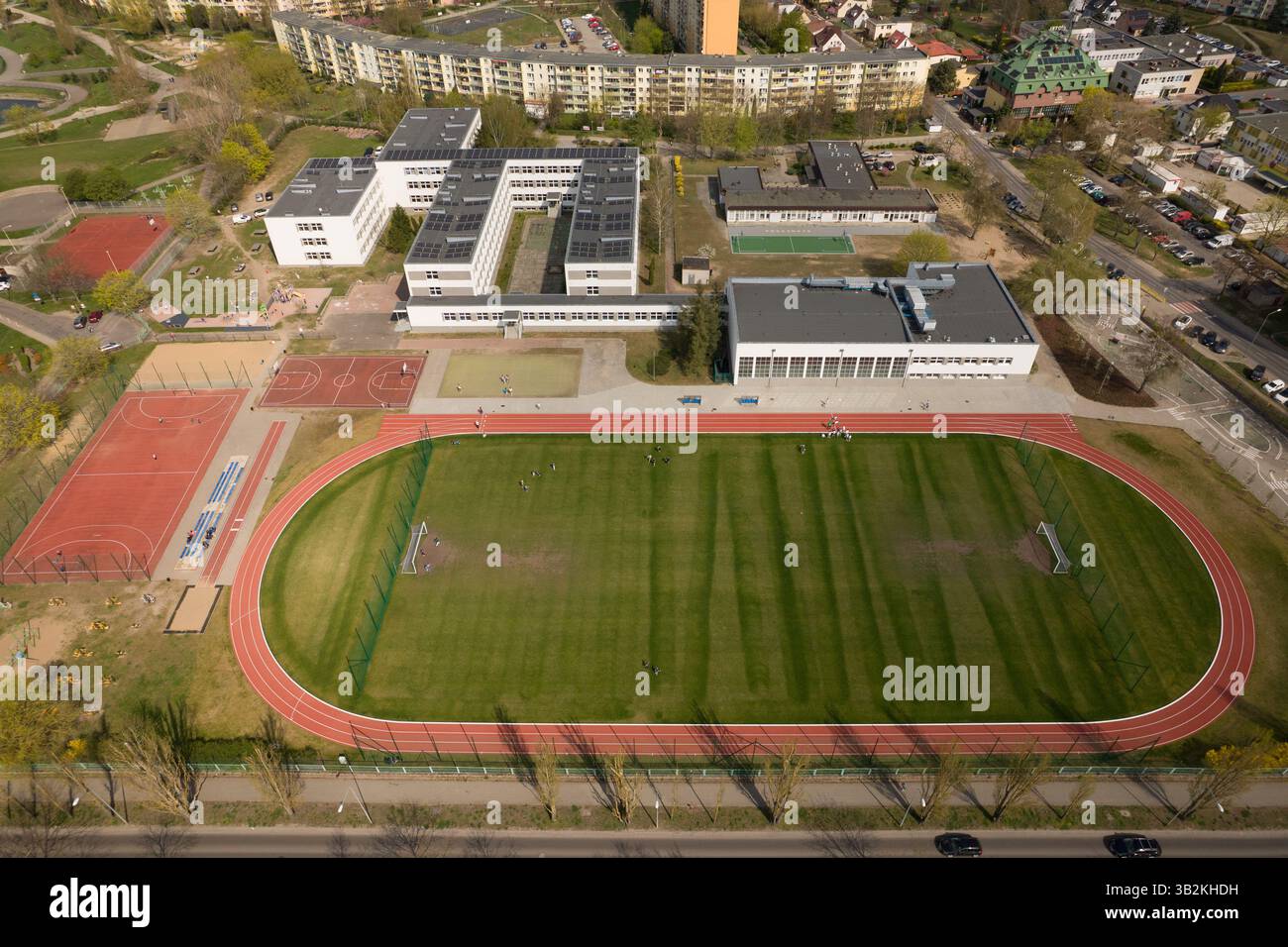 Schulkomplex mit Sportfeldern und Stadtlandschaft - aus der Vogelperspektive. Stockfoto
