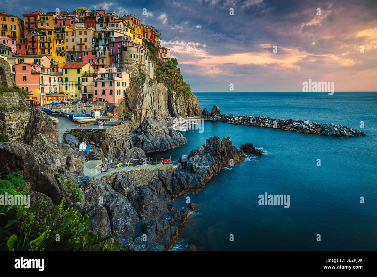 Eines der berühmtesten und schönsten Dörfer der Welt mit farbenfrohen Häusern am Meer auf den Klippen bei Sonnenuntergang, Manarola, Cinque Terre, Ligurien, Italien Stockfoto