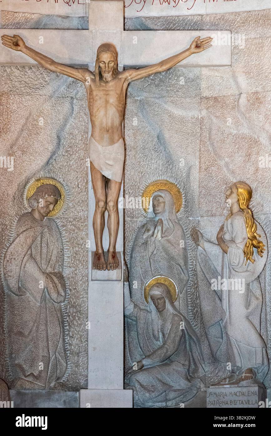 Ribadesella, Spanien - 26. April 2025: Statue des gekreuzigten Jesus Christus am Kreuz dargestellt mit Maria, Maria Magdalena und Johannes. Stockfoto