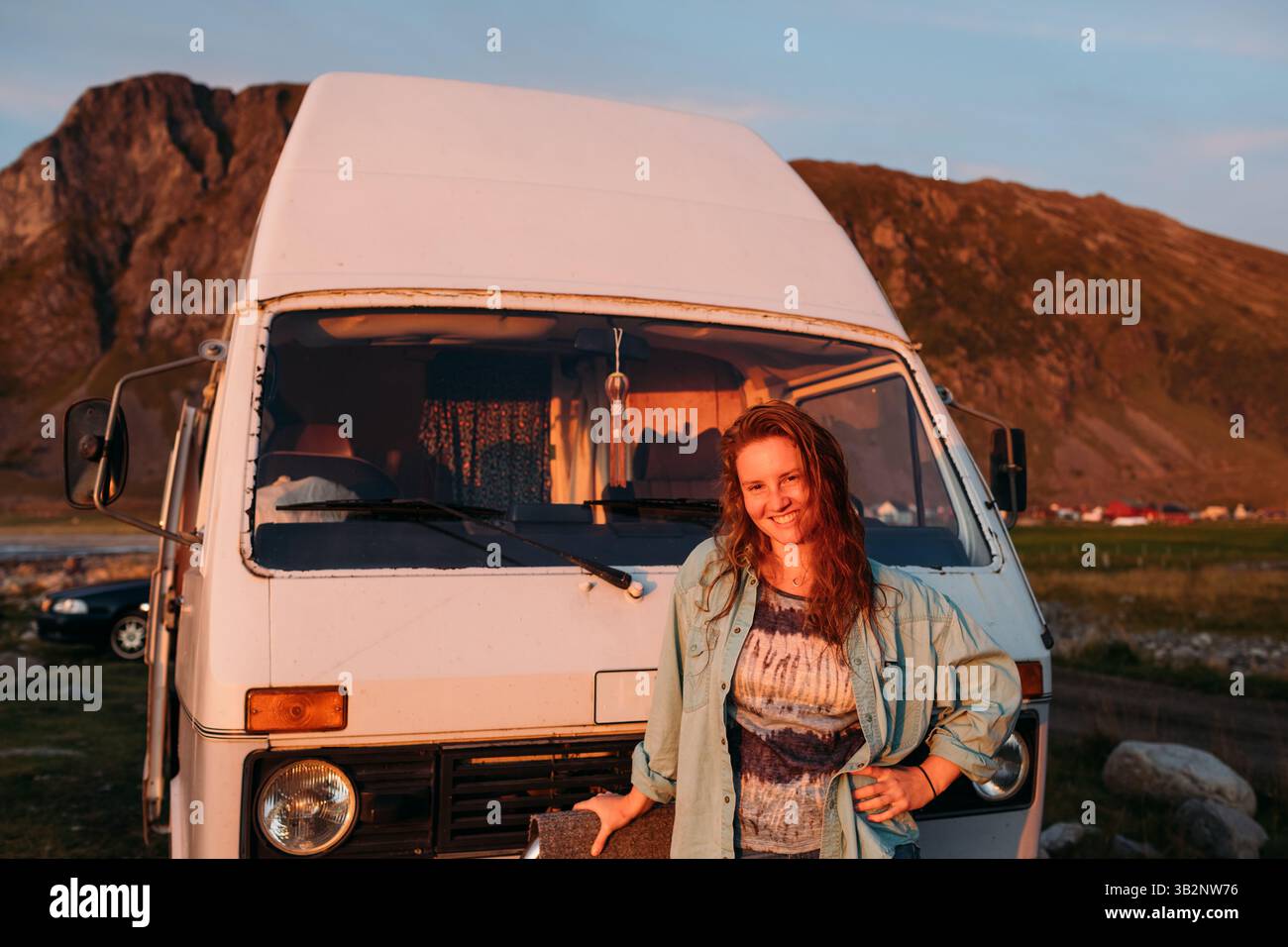 Lächelnde Frau, die vor dem Wohnmobil steht Stockfoto