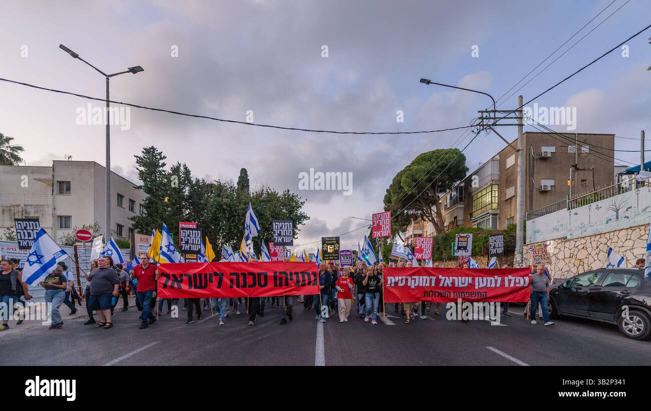 Haifa, Israel - 26. April 2025: Menschen mit verschiedenen Schildern und Flaggen nehmen an einer Protestkundgebung Teil, die die Beendigung des Krieges und die Vollendung der Geiselnahme fordert Stockfoto