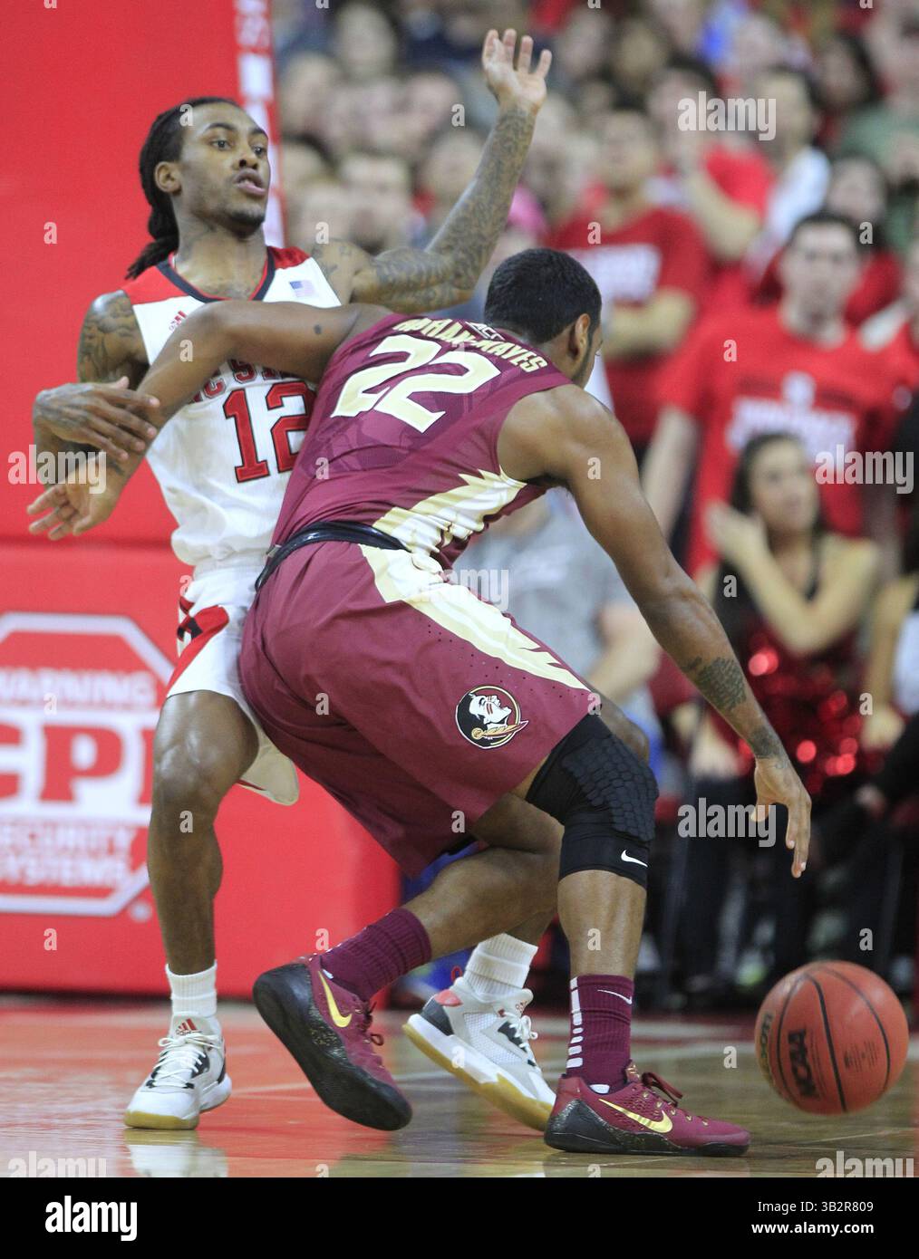 13. Januar 2016 – Raleigh, North Carolina, USA – der Cat Barber des Bundesstaates North Carolina (12) wird am Mittwoch, den 13. Januar 2016 in der PNC Arena in Raleigh, N.C., wegen eines Fouls gerufen, als er Xavier Rathan-Mayes (22) des Bundesstaates Florida während der ersten Halbzeit in der PNC Arena in Raleigh, N.C., bewacht. (Bild: © Ethan Hyman/TNS via ZUMA Wire) Stockfoto