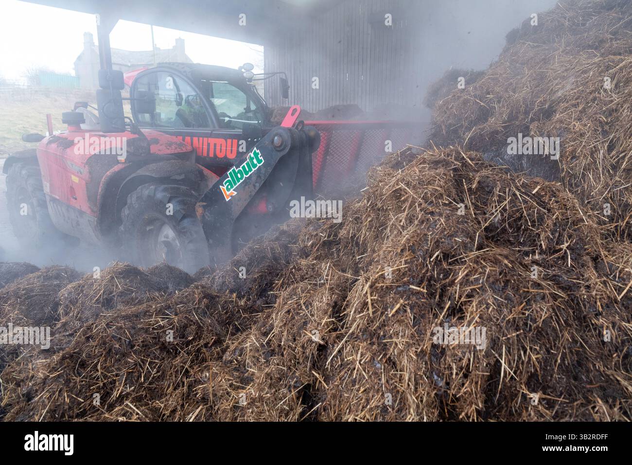 Eine Kompostmischung mit einem Lader auf einem Bauernhof, der sich zur Herstellung von torffreiem Kompost diversifiziert hat. Cumbria, Großbritannien. Stockfoto