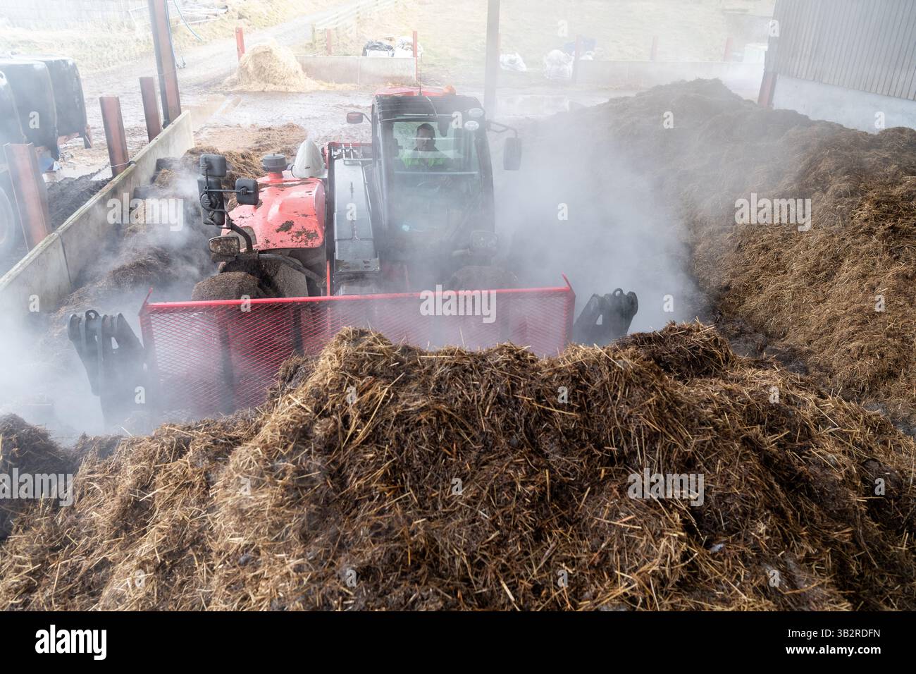 Eine Kompostmischung mit einem Lader auf einem Bauernhof, der sich zur Herstellung von torffreiem Kompost diversifiziert hat. Cumbria, Großbritannien. Stockfoto