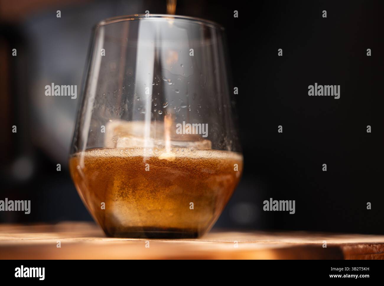 Ein erfrischendes Glas Bier steht derzeit auf einem rustikalen Holztisch, der von jedem, der vorbeikommt, genossen werden kann Stockfoto