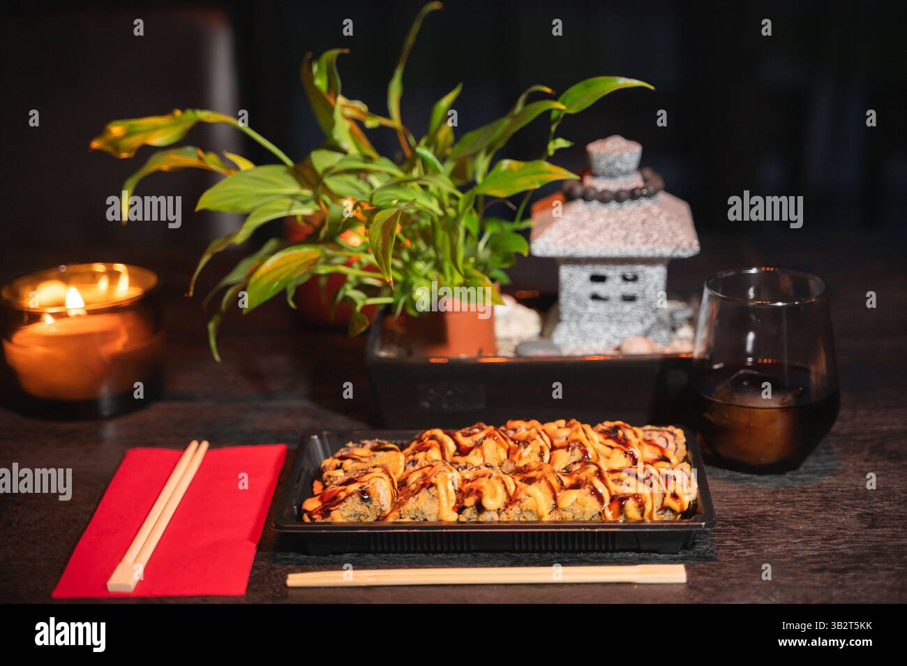 Genießen Sie köstliches Sushi in einer ruhigen Atmosphäre, gefüllt mit schönen Pflanzen und beruhigender sanfter Beleuchtung Stockfoto