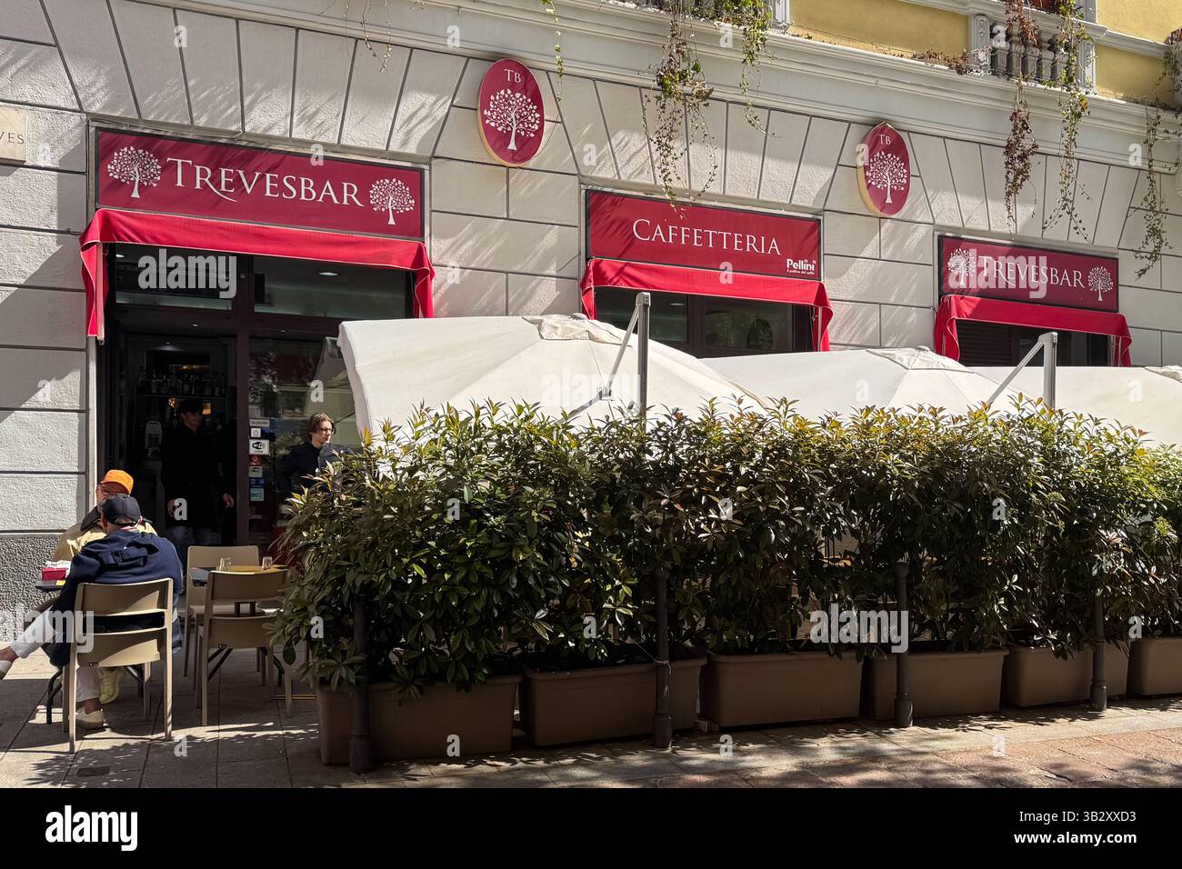 Mailand, Italien - 07. April 2025: Trevesbar Caffetteria mit roten Markisen, Terrassensitzen und Topfgrün Stockfoto