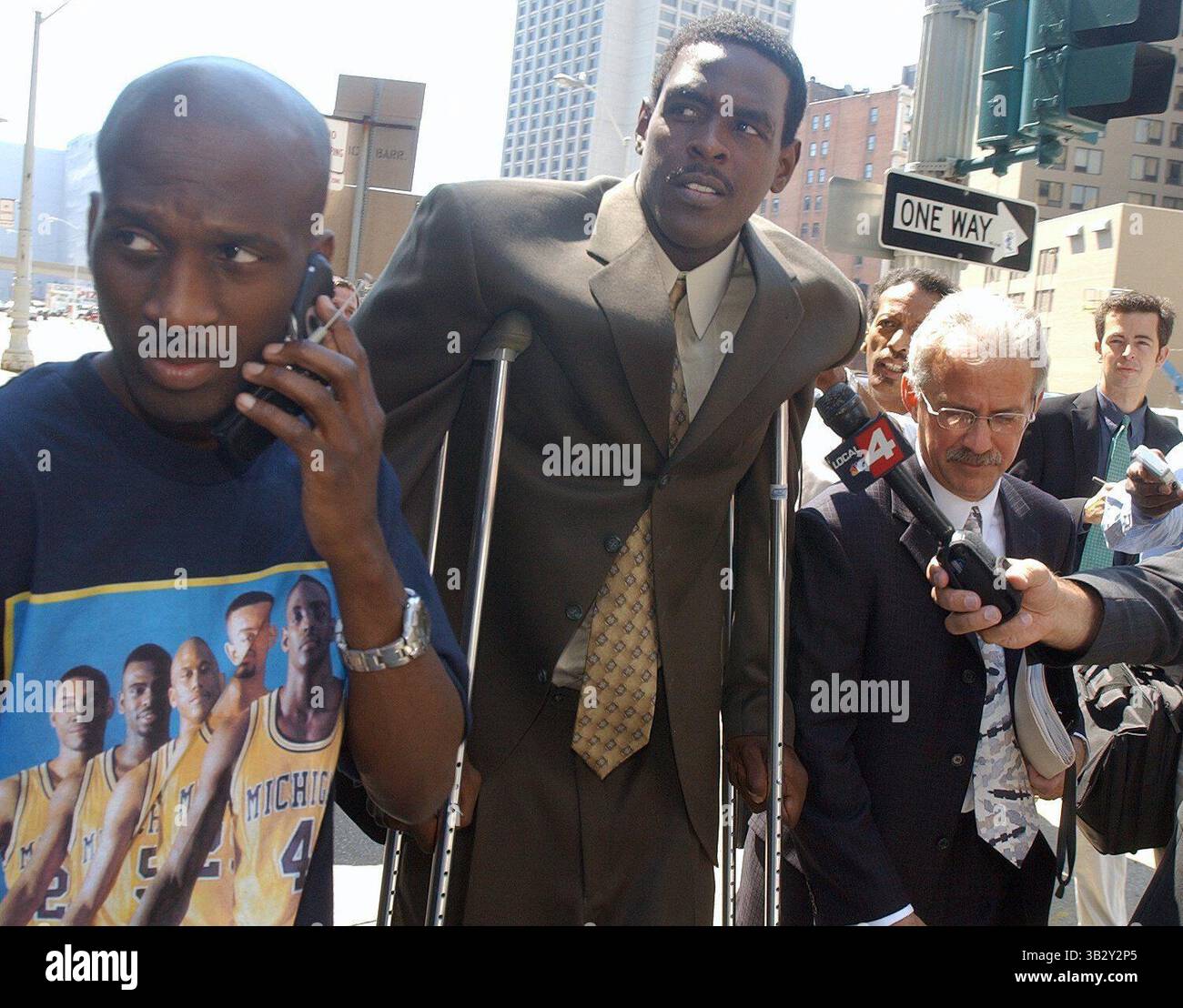 15. Juli 2003 - Michigan, MI, USA - GESCHICHTE: Chris Webber bekennt sich vor dem Bundesgericht schuldig. DATUM: Montag, 14. Juli 2003.BILDUNTERSCHRIFT: Ehemaliger Basketballspieler und aktueller Sacramento Kings Chris Webber geht auf Krücken des Bundesgerichts in Detroit, nachdem er sich schuldig bekannt hat. Kevin Colson, Webbers High School Freund, ist links in einem Fab 5 T-Shirt. Rechts ist Steven Fishman, Webbers Anwalt. (Kreditbild: © Detroit Free Press via ZUMA Wire) Stockfoto