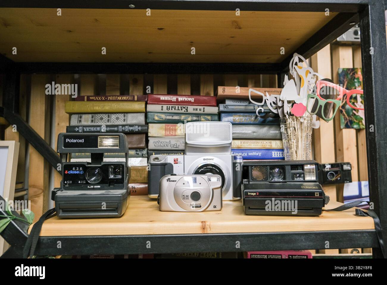 Moskau, Russland, 14.07.2025 verschiedene alte Kameras stehen im Regal mit Büchern. Stockfoto