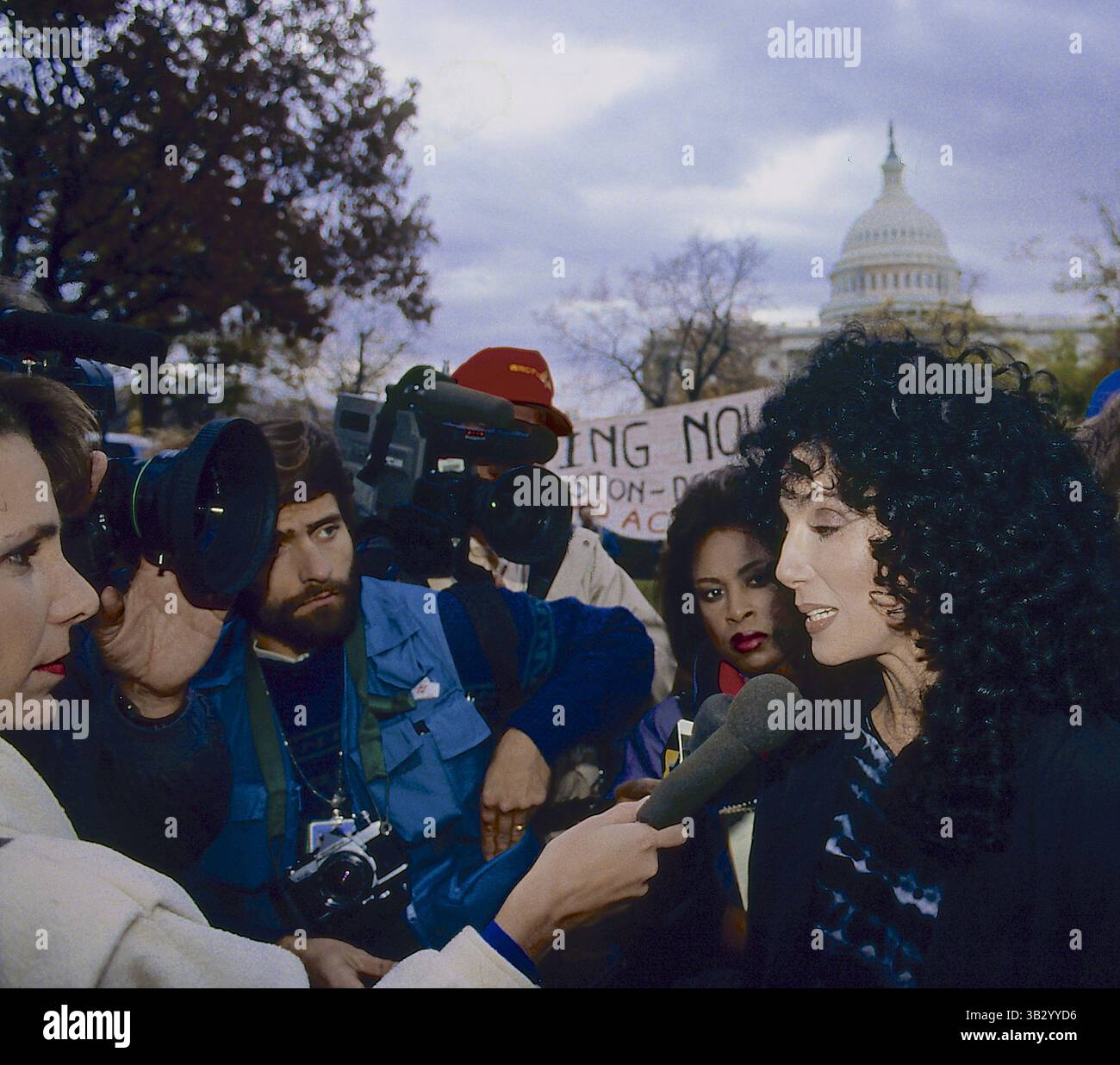 1. April 2015: Washington, District of Columbia, Vereinigte Staaten von Amerika - Washington, DC. 1988.Cher nimmt sich die Zeit, Fragen von Reportern zu beantworten, während er an einer Obdachlosen-Demonstration in Washington DC teilnimmt. Cher wurde in Cherilyn Sarkisian geboren. Sie wird als Verkörperung der weiblichen Autonomie in einer männlich dominierten Branche beschrieben und ist bekannt für ihre unverwechselbare kontrastierende Stimme und für ihre Arbeit in verschiedenen Bereichen der Unterhaltung sowie für verschiedene Stile und Auftritte während ihrer Karriere, was dazu geführt hat, dass sie den Spitznamen The Goddess of Pop erhielt. Credit: Mark Reinstein (Credit Image: © Mark Reinste) Stockfoto