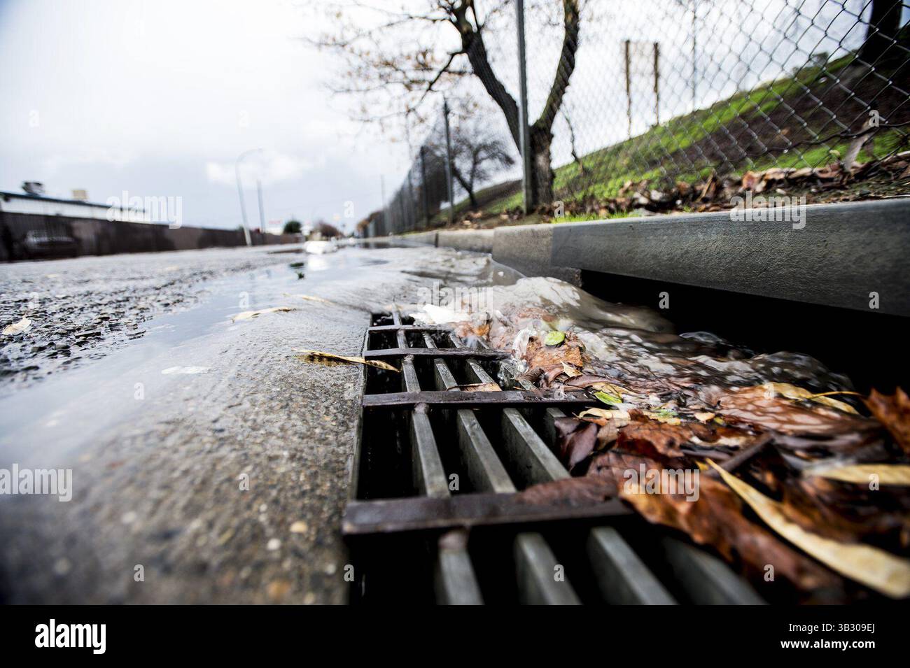 6. Januar 2016 – Regenwasser stürzt in der Nähe eines überfluteten Abschnitts der 14. Straße einen Sturm hinunter, während El NiÃ±o Stürme am Mittwoch, den 6. Januar 2016, durch Merced, Kalifornien, strömen. (Kreditbild: © Andrew Kuhn/The Merced Sun Star Via ZUMA) Stockfoto