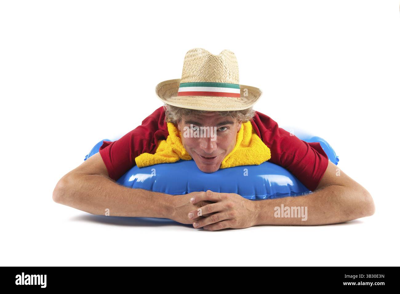 Erwachsener Mann mit italienischen Hut liegt am Strand Stockfoto