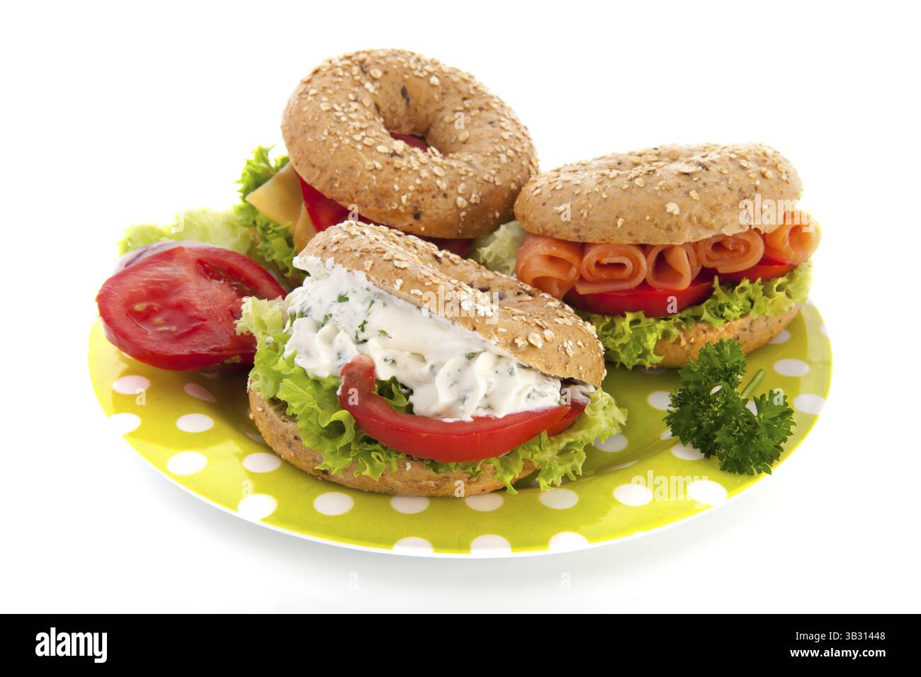 Drei frische Bagels mit luxuriösen Aufstrichen auf weißem Hintergrund Stockfoto