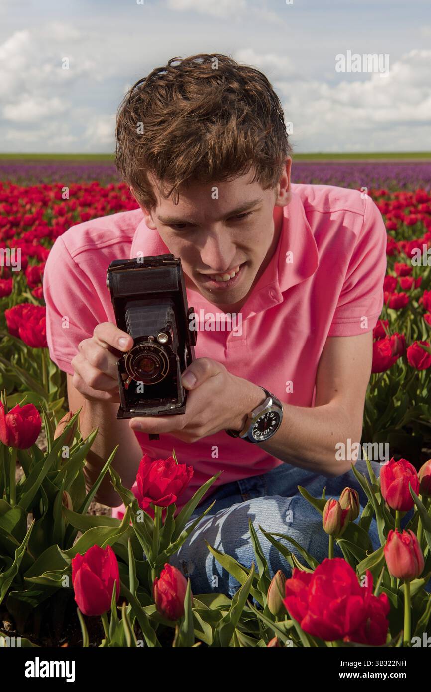 Portrait von Ayoung Mann Fotografieren in Tulpen Feld mit alten Vintage-Kamera Stockfoto