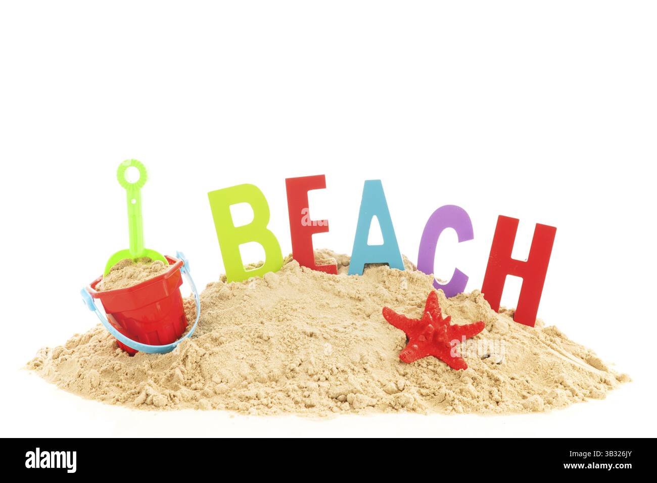 Haufen Sand mit Strandartikeln und Wort für Urlaub Stockfoto