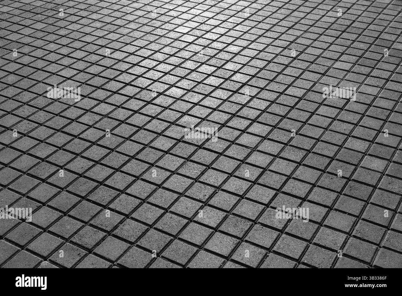 Monochrome perspektivische Ansicht des quadratischen Pflasters mit sich wiederholenden Mustern und geometrischem Design Stockfoto