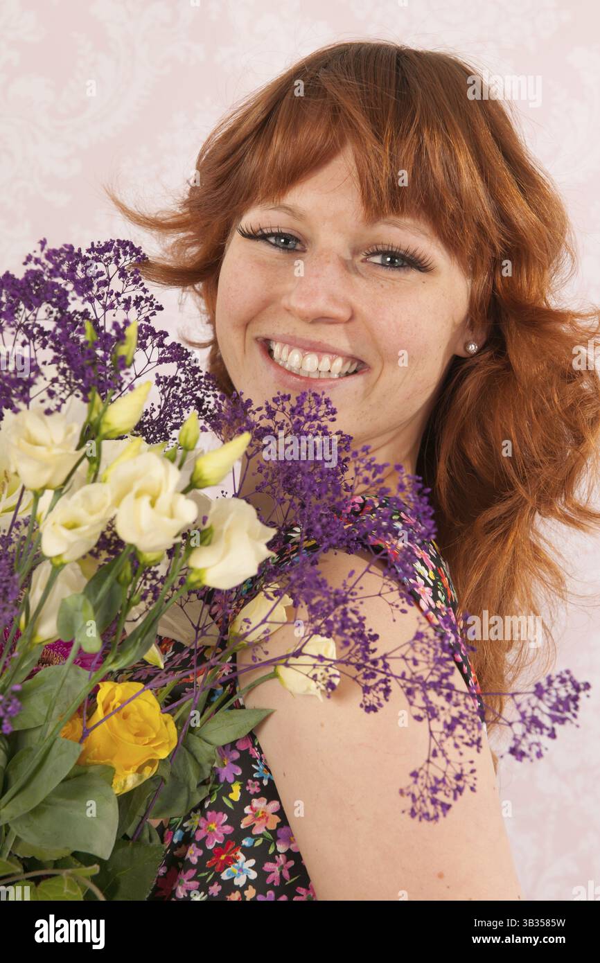 Porträt der Frau im Innenraum mit bunter Strauß Blumen Stockfoto