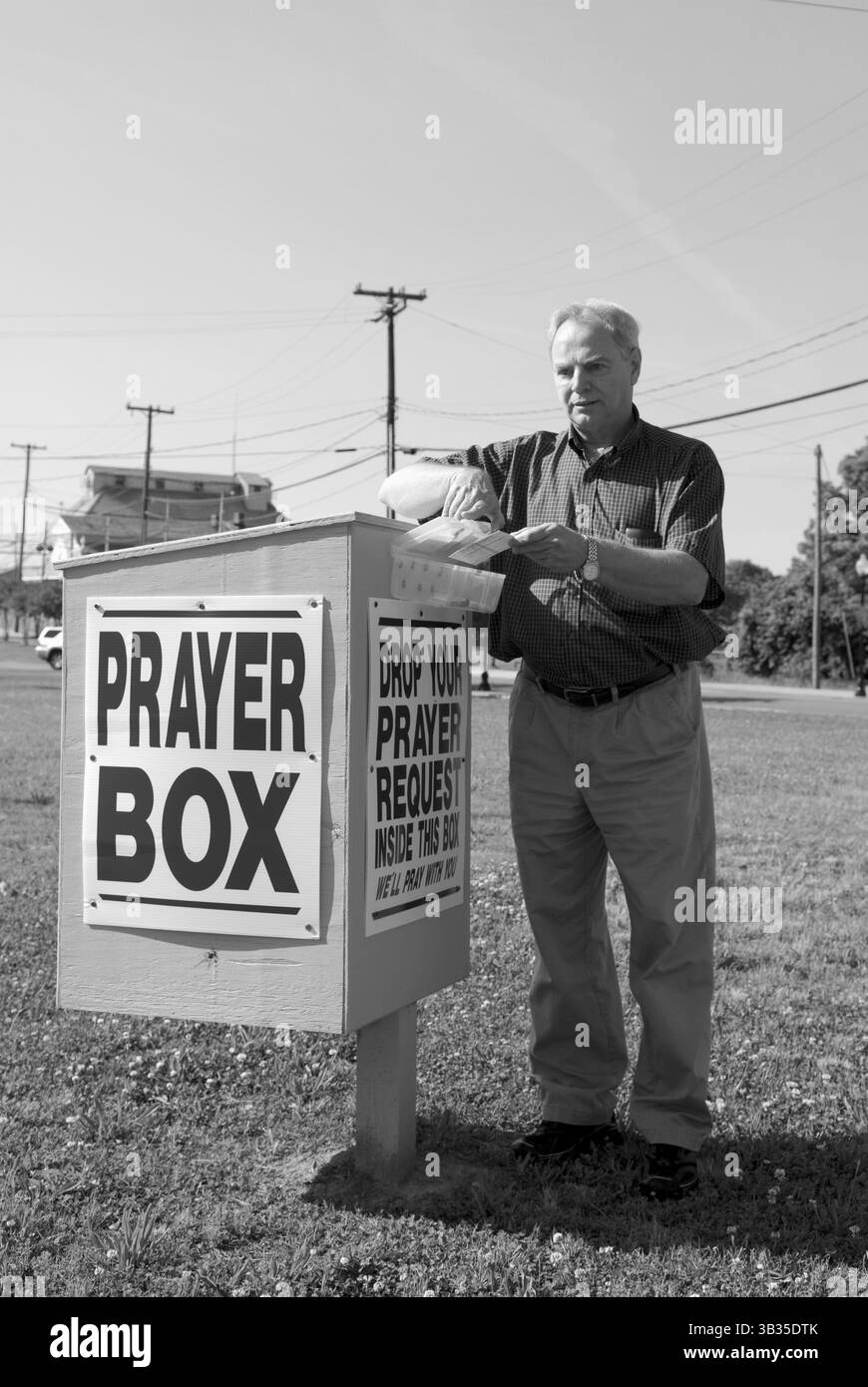 Kaukasischer Mann, der Gebetsanfrage in der Gebetsbox der Kirche in den USA stellt Stockfoto