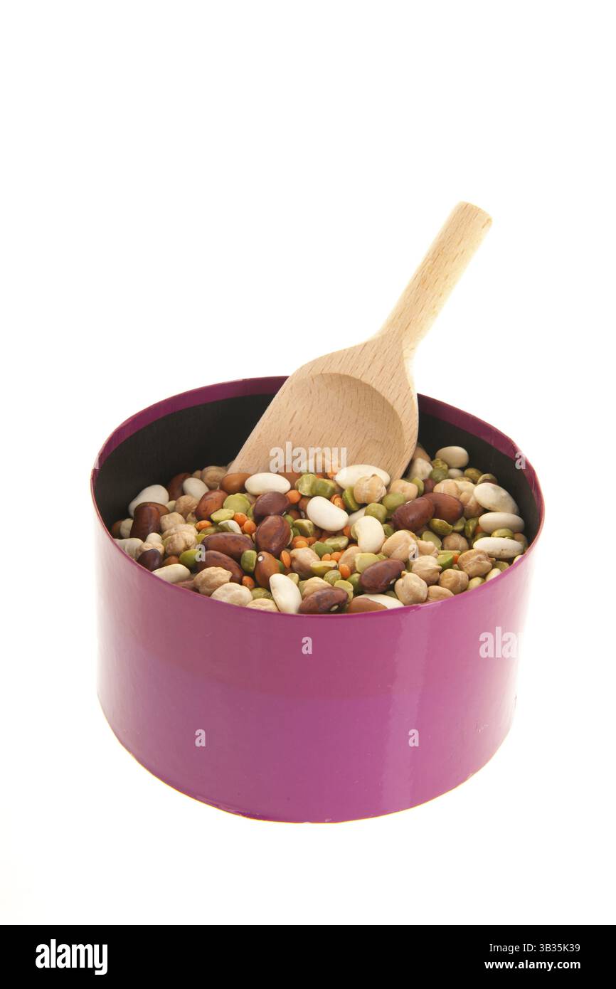 Gemischte Hülsenfrüchte in rosa Box mit Holzlöffel auf weißem Hintergrund Stockfoto