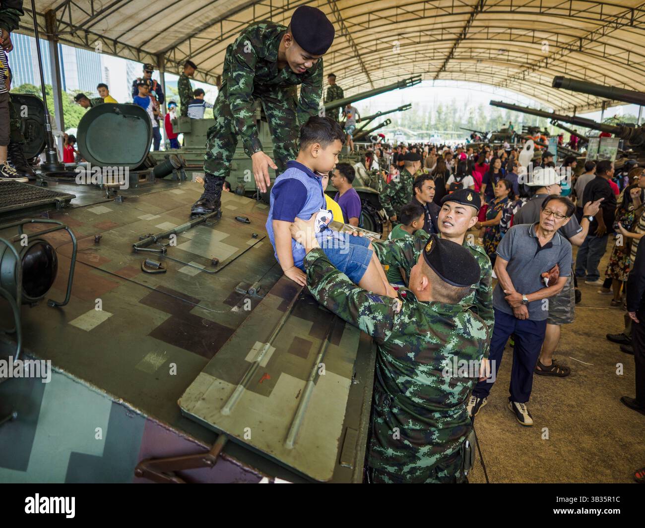 13. Januar 2018 - Bangkok, Bangkok, Thailand - thailändische Soldaten helfen einem Kind, während der Aktivitäten zum Kindertag im 2. Kavallerie-Lager der Königsgarde der Royal Thai Army im Zentrum von Bangkok von einem gepanzerten persönlichen Träger vom Typ 85 zu springen. Der Kindertag wird auf Thailändisch „Wan DEK“ genannt. Viele Regierungsbüros und Militärbasen bieten spezielle Aktivitäten für Kinder an, ebenso wie Einkaufszentren. Thailand kaufte den Typ 85 von China. (Kreditbild: © Sean Edison via ZUMA Wire) Stockfoto