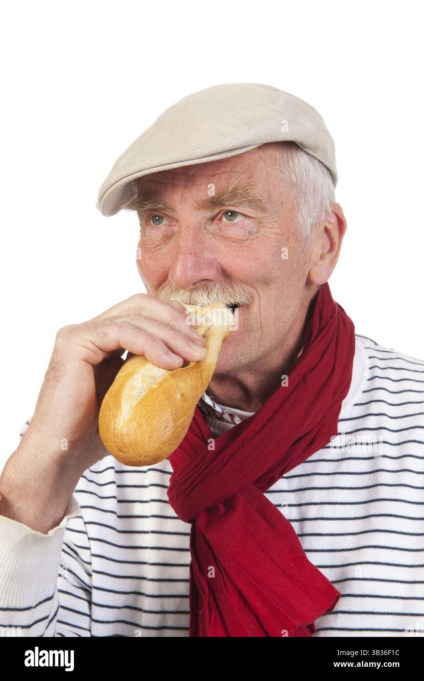 Porträt senior Mann mit Mütze und Schal Essen Baguette Stockfoto