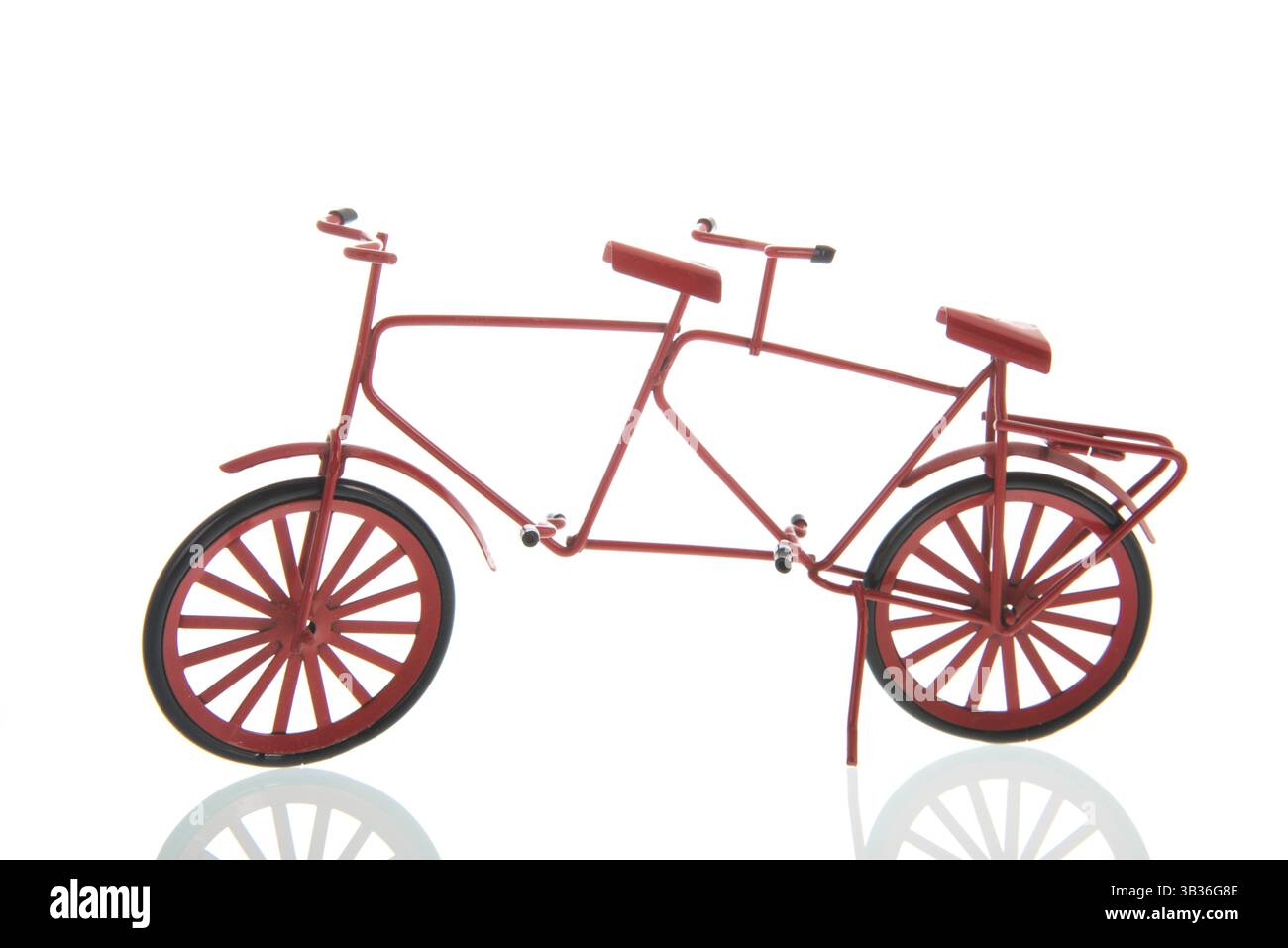 Ein rotes Fahrrad mit Sitzen und Pedalen für zwei Fahrer, einer hinter dem anderen isoliert auf weißem Hintergrund Stockfoto