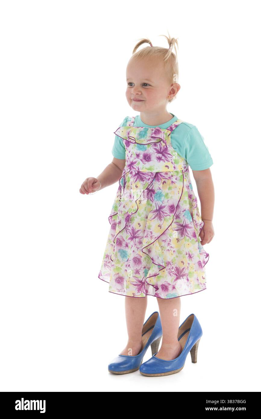 Kleinkind Mädchen stehen Inmothers große Fußstapfen, die isoliert auf weißem Hintergrund Stockfoto
