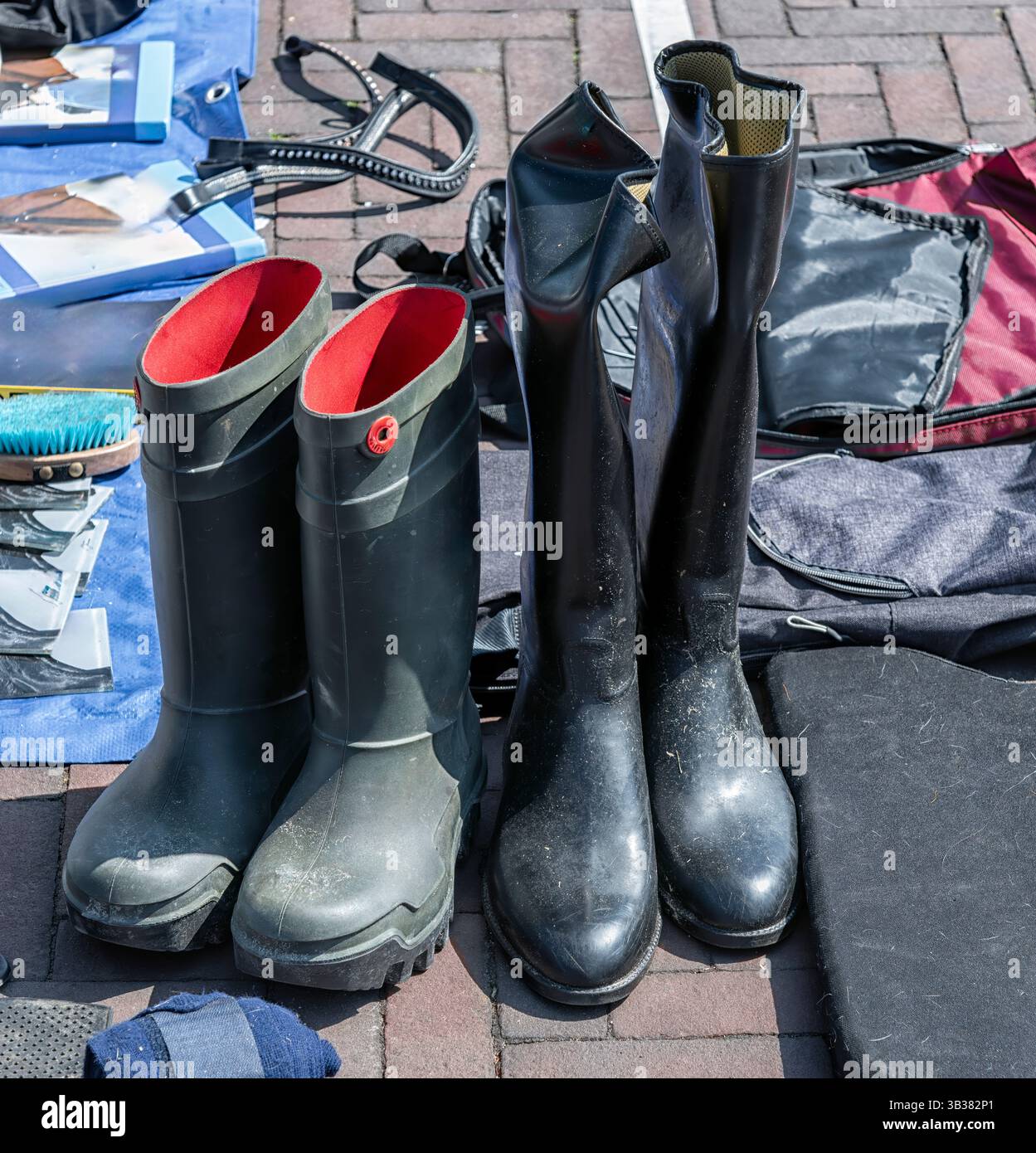 Zwei Paar Stiefel in Schwarz und Grün stehen draußen auf einem Straßenmarkt Stockfoto