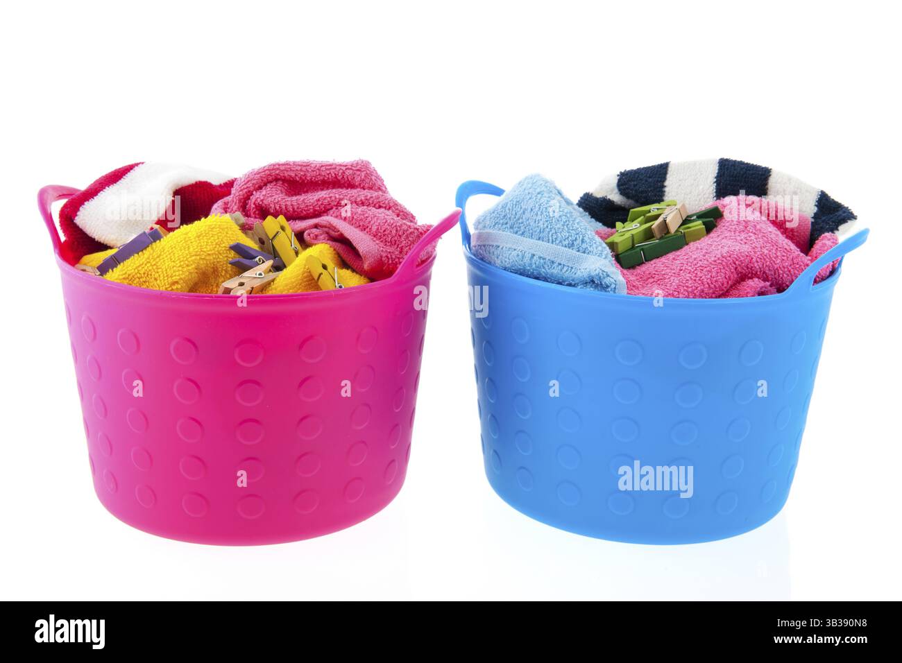 Volle Wäschekörbe in rosa und blau voller Handtücher und Kleidung pins Stockfoto