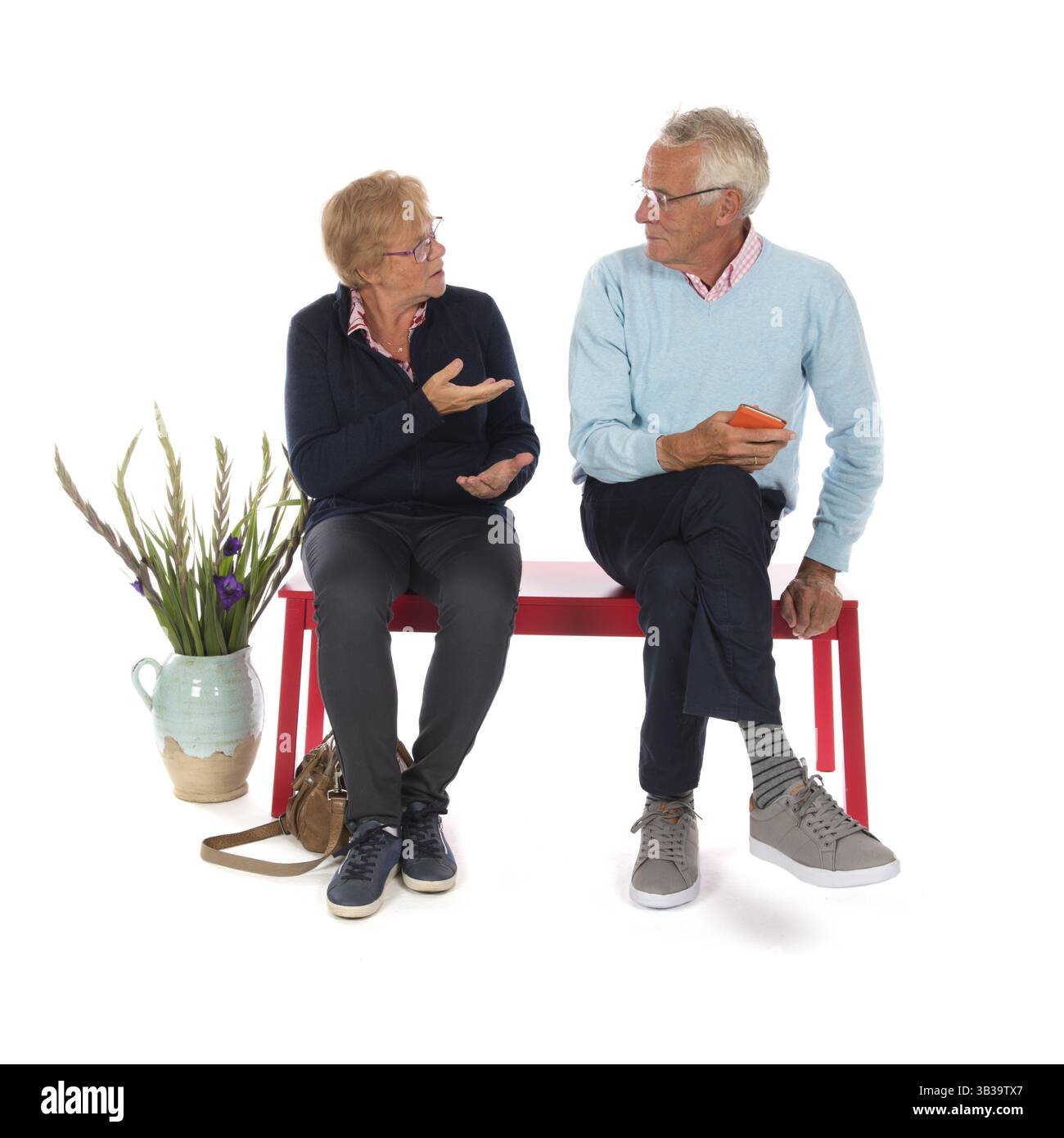 Seniorenpaar sitzt im Warteraum isoliert auf weißem Hintergrund Stockfoto
