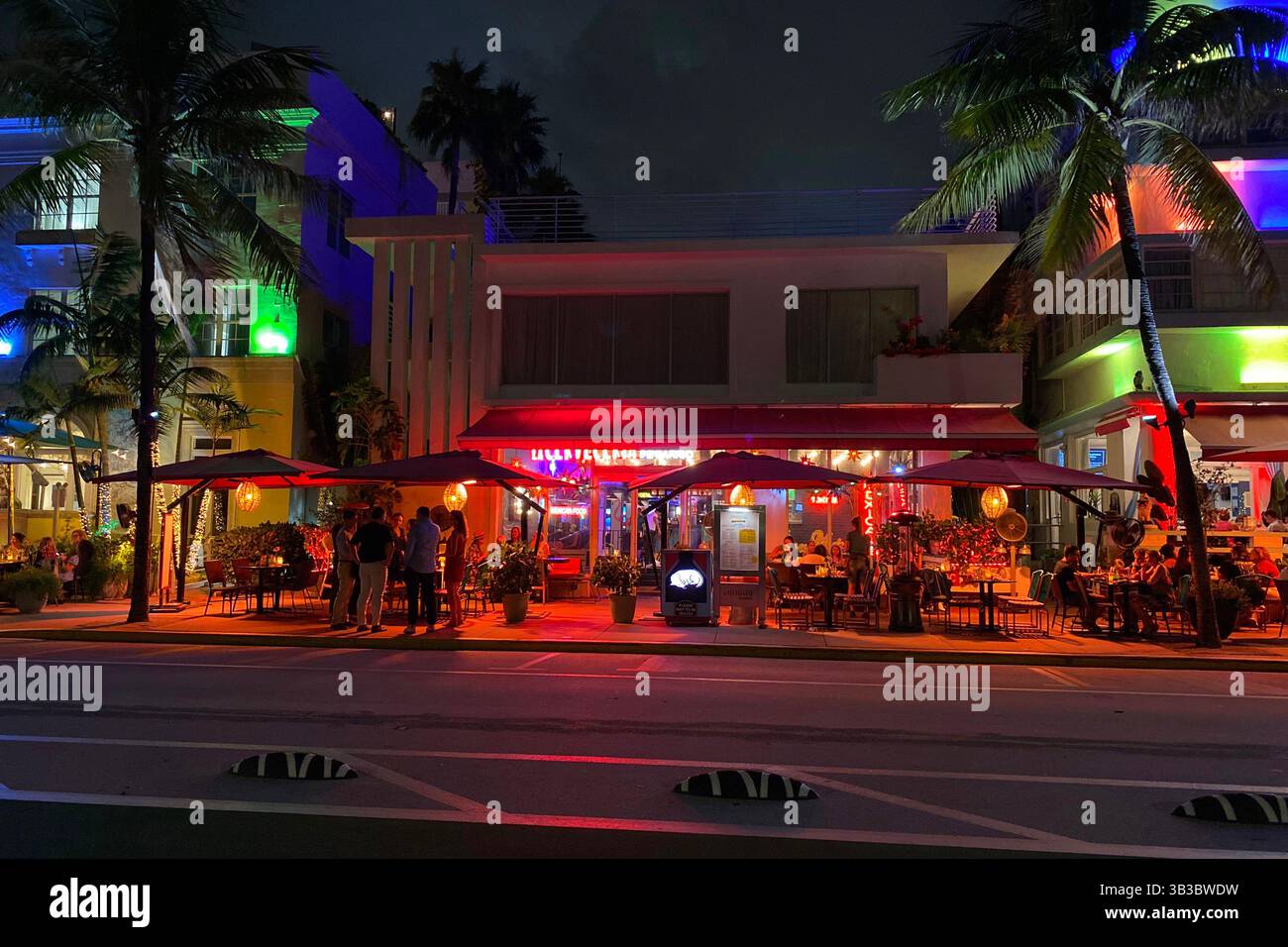 South Beach Miami Nachtlichter mit Palmen und geschäftigem Ocean Drive Stockfoto